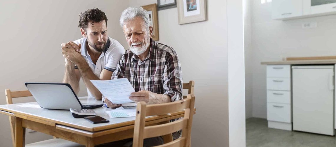 picture of elderly man and family member reviewing finances